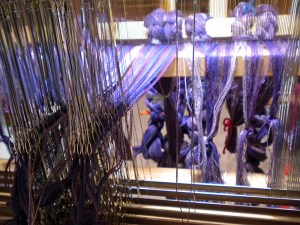 View from the back of the threads coming through the reed and the heddles.