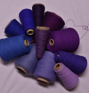 Purple and blue yarn on white background